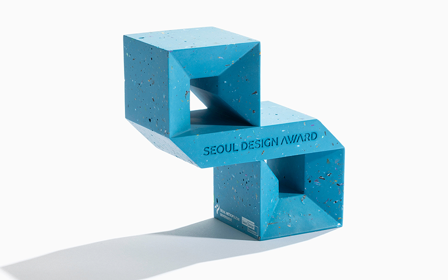 Vista a tre quarti del trofeo Seoul Design Award, con la cornice superiore appoggiata sulla fascia diagonale e quella inferiore come base